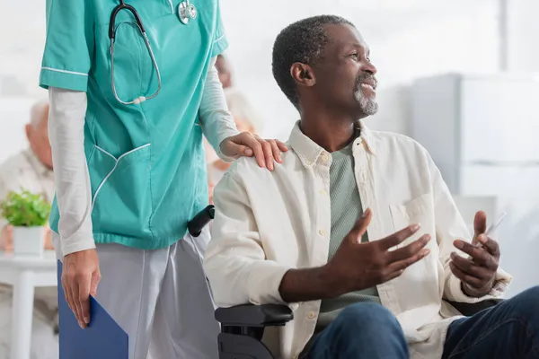 Smiling African American Patient Holding Smartphone While Sitting Wheelchair Nurse — Stock Photo, Image