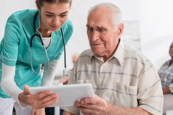 Ung Sjuksköterska Håller Digital Tablett Nära Äldre Patient Vårdhem — Stockfoto