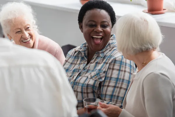 老人ホームでお茶と先輩の友人を見て興奮アフリカ系アメリカ人女性 — ストック写真