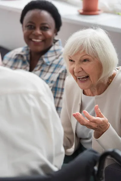 Positive Woman Talking Blurred Friend Nursing Home — Stock Photo, Image