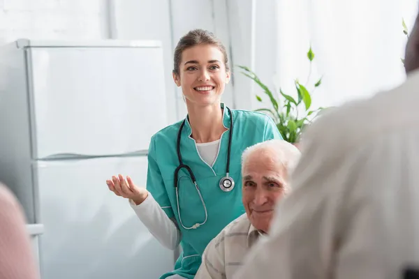 Enfermera Positiva Con Estetoscopio Cerca Pacientes Mayores Interraciales Residencia Ancianos —  Fotos de Stock