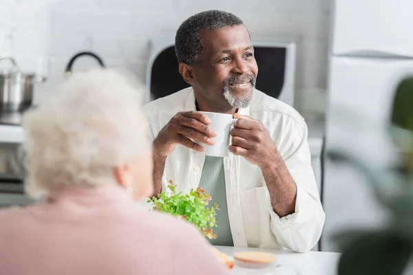 Smiling Senior Man Holding Cup Blurred Friend Nursing Home — ストック写真