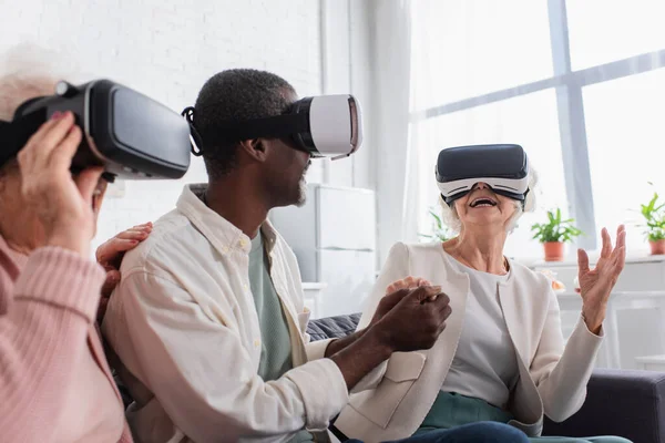 Cheerful Senior Woman Holding Hand African American Friend While Gaming — Stock Photo, Image