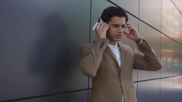 Geschäftsmann Nutzt Smartphone Und Trägt Kopfhörer Draußen Stockvideo