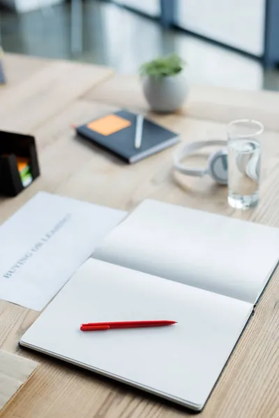 Quaderno Con Penna Vicino Vetro Acqua Cuffie Ufficio — Foto Stock