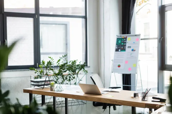 Laptop Neben Notizbuch Und Verschwommenes Flipchart Büro — Stockfoto