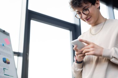 Ofiste cep telefonu kullanan genç işadamlarının düşük açılı görüntüsü 