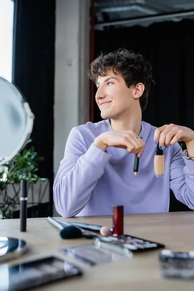 Orang Transgender Positif Memegang Kosmetik Dekoratif Dekat Cermin Kabur — Stok Foto