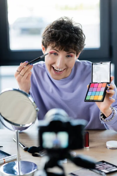 Excitada Pessoa Transgênero Aplicando Sombra Nos Olhos Perto Espelho Câmera — Fotografia de Stock