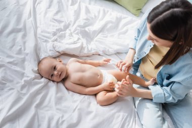 Esmer kadının bebek bezi takmış küçük oğlunun yanında oturduğunu gördüm.