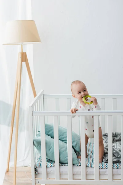 Little Boy Romper Biting Rattle Ring While Standing Crib — Stock Photo, Image