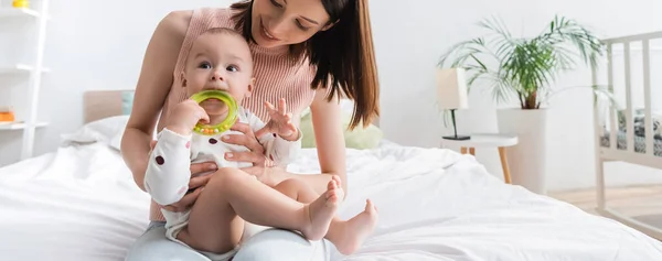 Feliz Mamá Cerca Niño Pequeño Mordiendo Sonajero Anillo Pancarta — Foto de Stock