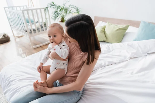 Brunetka Kobieta Siedzi Mały Syn Łóżku Domu — Zdjęcie stockowe