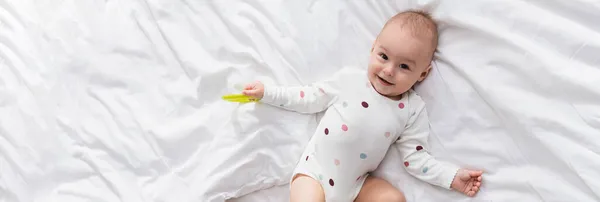 Top View Cheerful Toddler Boy Lying White Bedding Rattle Ring — Stock Photo, Image