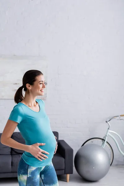 Alegre Embarazada Deportista Tocando Vientre Sala Estar —  Fotos de Stock