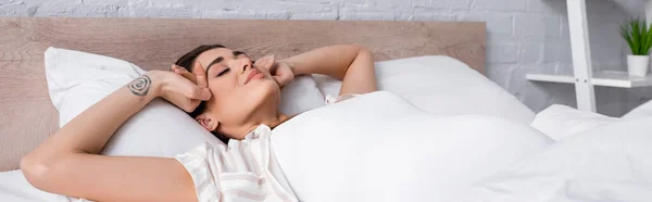 閉じられた目のベッドに横になって入れ墨と喜びの女性 バナー — ストック写真