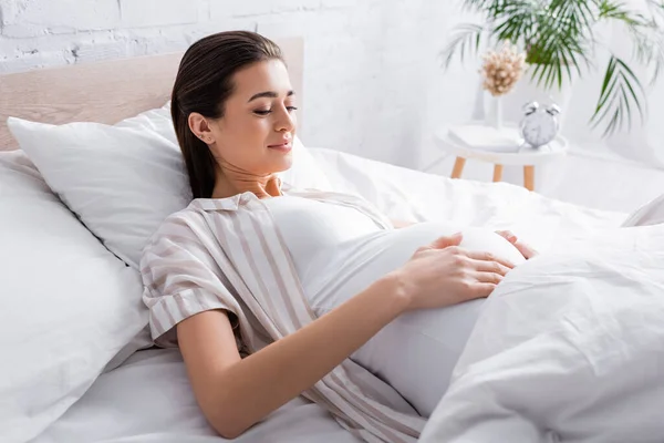 Mulher Grávida Satisfeito Tocando Barriga Enquanto Deitado Cama — Fotografia de Stock