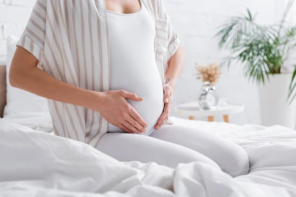 Częściowy Widok Wytatuowanej Kobiety Ciąży Dotykającej Brzucha Sypialni — Zdjęcie stockowe
