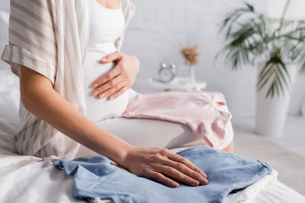 Vista Recortada Mujer Embarazada Cerca Ropa Bebé Cama —  Fotos de Stock