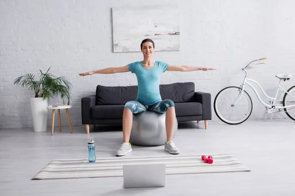 Glad Gravid Kvinna Sportkläder Tränar Fitness Boll Nära Laptop Vardagsrummet — Stockfoto