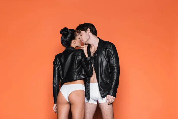 Sexiga Par Vita Underkläder Och Läderjackor Som Står Isolerade Orange — Stockfoto
