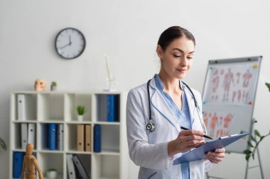 Klinikteki panoya yazan esmer doktor. 