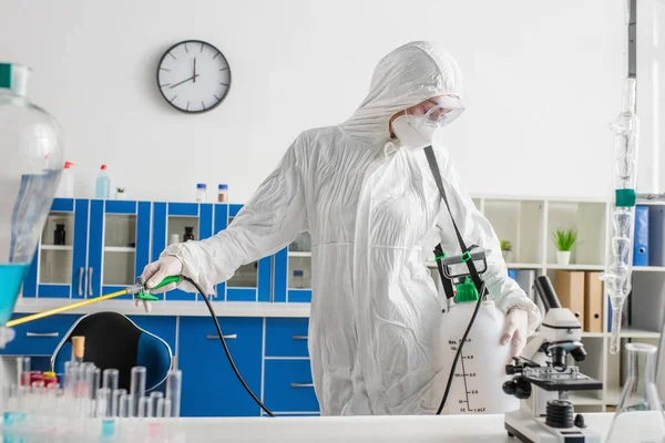 Cientista Terno Hazmat Fazendo Desinfecção Laboratório Perto Microscópio Tubos Ensaio — Fotografia de Stock