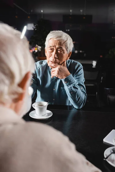 Pensive Senior Asian Man Looking Blurred Friend Meeting Cafe — Stock Photo, Image