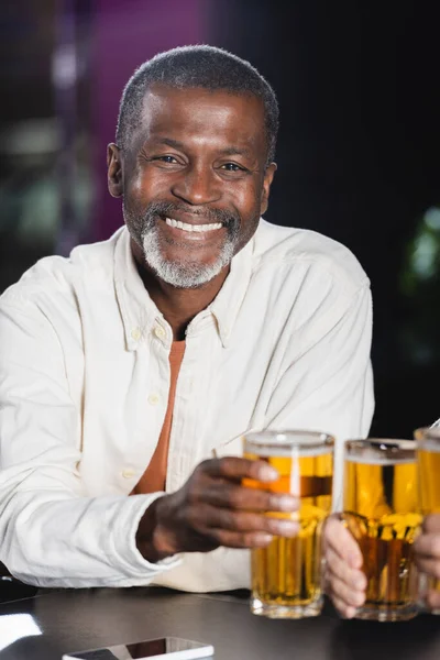 Senior Africký Američan Muž Úsměvem Kameru Při Cinkání Rozmazané Pivo — Stock fotografie