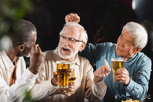 Joyful Senior Multiethnic Men Drinking Beer While Spending Time Pub — Stock Photo, Image