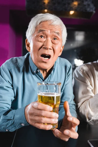 Sorprendido Asiático Hombre Con Vaso Cerveza Viendo Campeonato Deportes Bar — Foto de Stock
