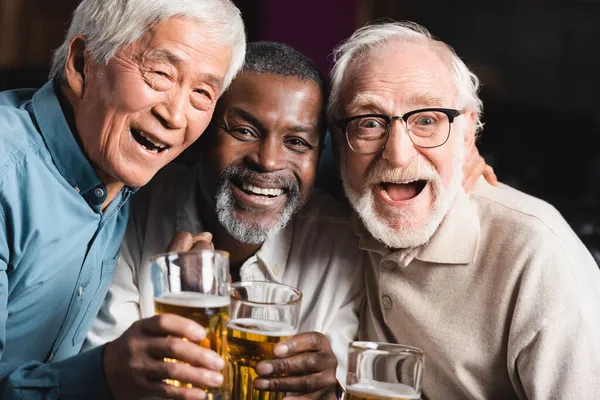 Senior Overjoyed Multiethnic Friends Looking Camera While Holding Glasses Beer — Stock Photo, Image