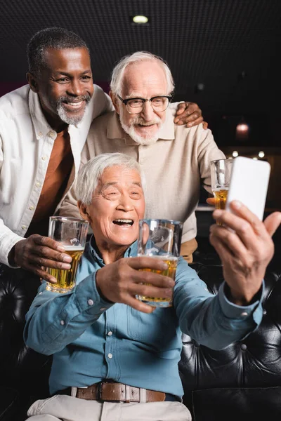Szczęśliwy Azji Człowiek Biorąc Selfie Starszy Wielokulturowy Przyjaciele Piwo Pub — Zdjęcie stockowe