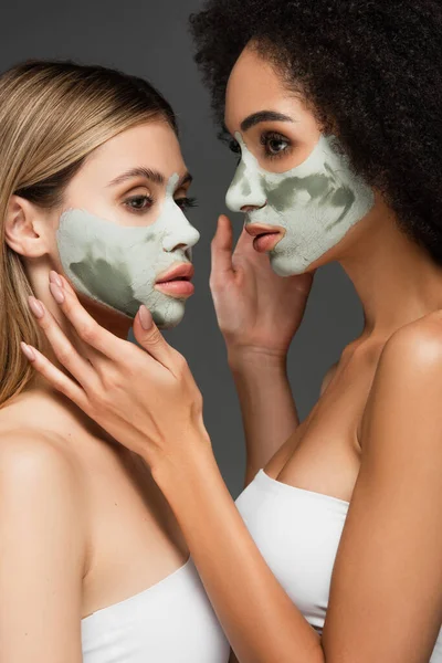 Mujeres Multiétnicas Máscaras Faciales Tocando Rostros Unos Otros Aislados Gris — Foto de Stock