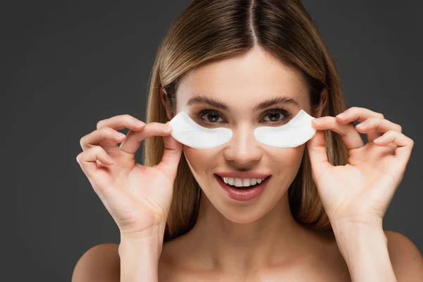 Smiling Woman Looking Camera While Holding Eye Patches Isolated Grey — Stock Photo, Image