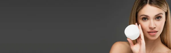 Молода Жінка Чистою Шкірою Тримає Косметичний Крем Ізольовано Сірому Банер — стокове фото