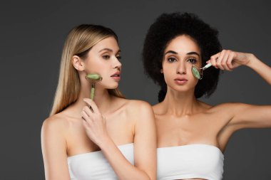 Mükemmel derili ırklar arası kadınlar gri renkte yeşil bigudiler kullanıyorlar.