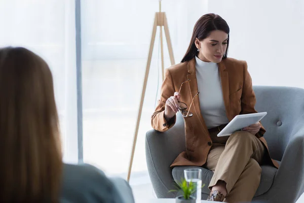 Psycholoog Zit Fauteuil Met Digitale Tablet Buurt Wazig Vrouw Spreekkamer — Stockfoto