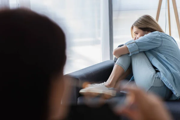 Depressive Frau Sitzt Auf Sofa Neben Verschwommenem Psychologen Sprechzimmer — Stockfoto