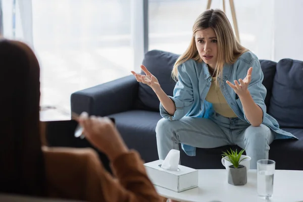 Mulher Infeliz Gesticulando Enquanto Conversava Com Psicólogo Desfocado Consultório — Fotografia de Stock