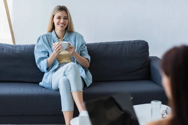 Mujer Sonriente Sentada Sofá Con Una Taza Durante Consulta Con — Foto de Stock