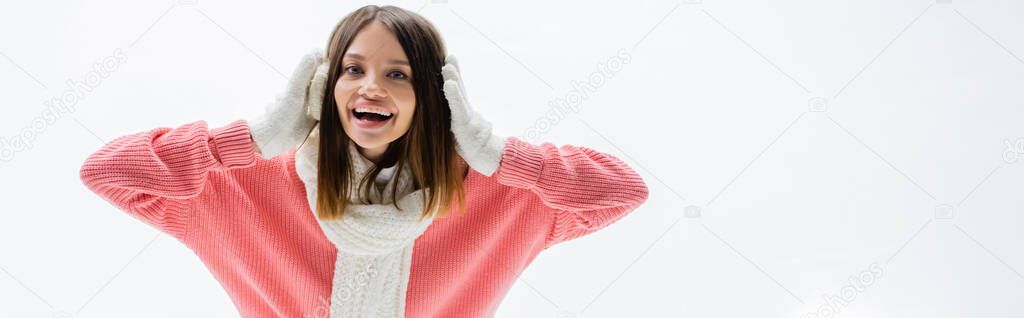 amazed young woman in ear muffs and scarf on ice rink, banner