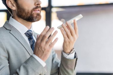 Ofisteki cep telefonuna ses masajı kaydeden işadamının görüntüsü. 