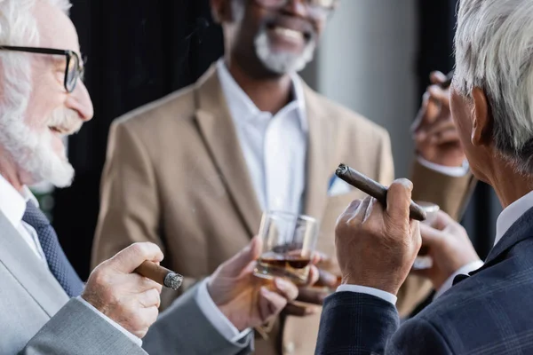 Senior Geschäftsmann Mit Glas Whiskey Und Zigarre Neben Lächelnden Multiethnischen — Stockfoto