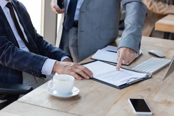 Cropped View Senior Businessman Pointing Contract Colleague Blurred Coffee Cup — Stock Photo, Image