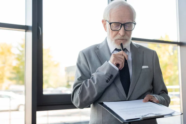 Doordachte Senior Zakenman Met Pen Tijdens Het Lezen Van Contract — Stockfoto