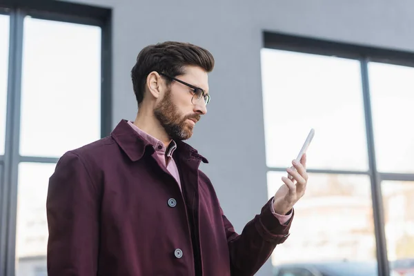 Bärtiger Geschäftsmann Trenchcoat Mit Smartphone Auf Der Straße — Stockfoto