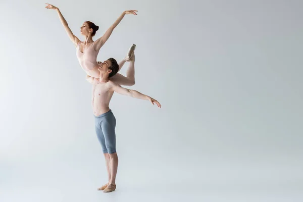 Volledige Lengte Van Shirtloze Balletdanser Tillen Ballerina Geïsoleerd Grijs — Stockfoto