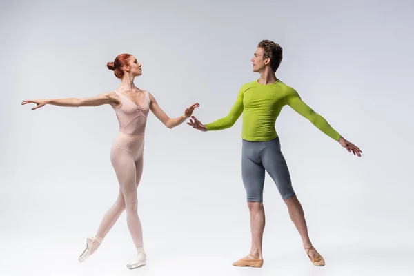 Volledige Lengte Van Jonge Balletdanser Kijken Naar Sierlijke Ballerina Grijs — Stockfoto