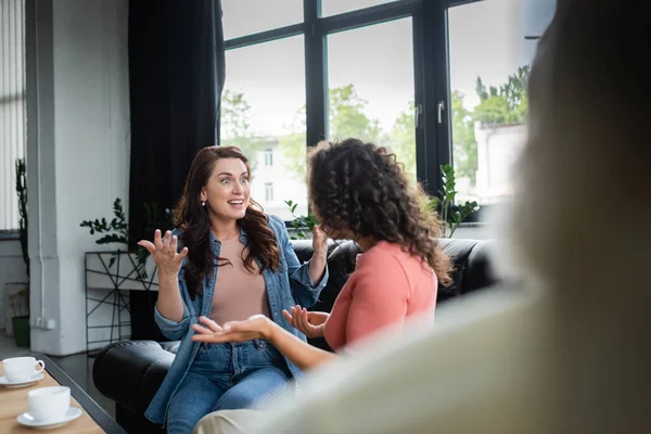 Excited Interracial Lesbian Couple Gesturing While Talking Consulting Room Blurred — Stock Photo, Image